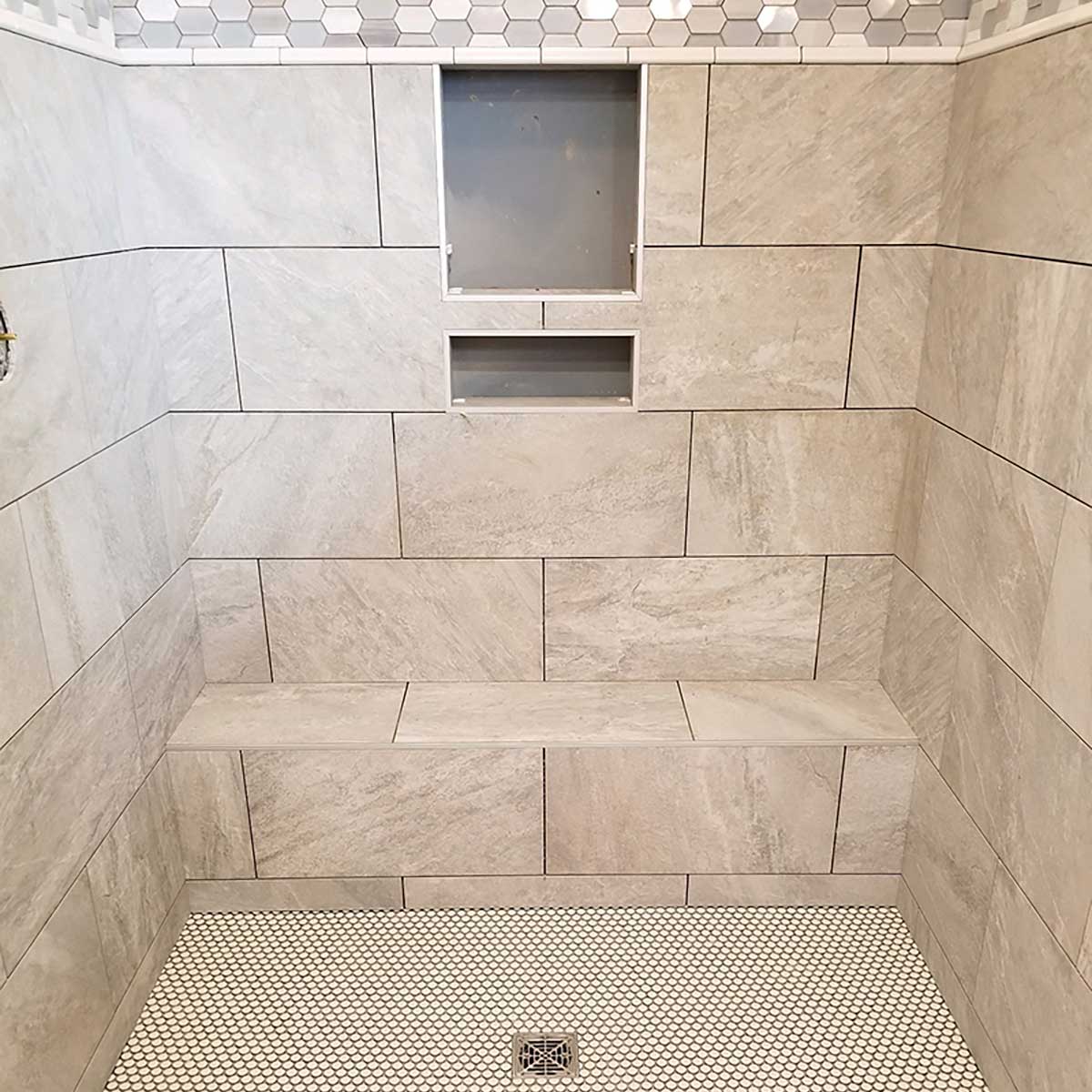 Installed ready-to-tile shower bench with custom tile finish in modern walk-in shower