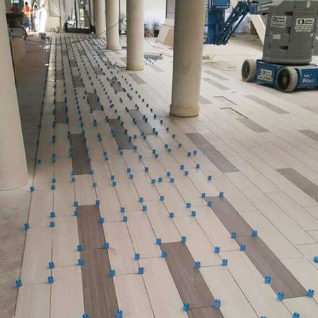 Contractor installing floor tile with the Proleveling leveling system