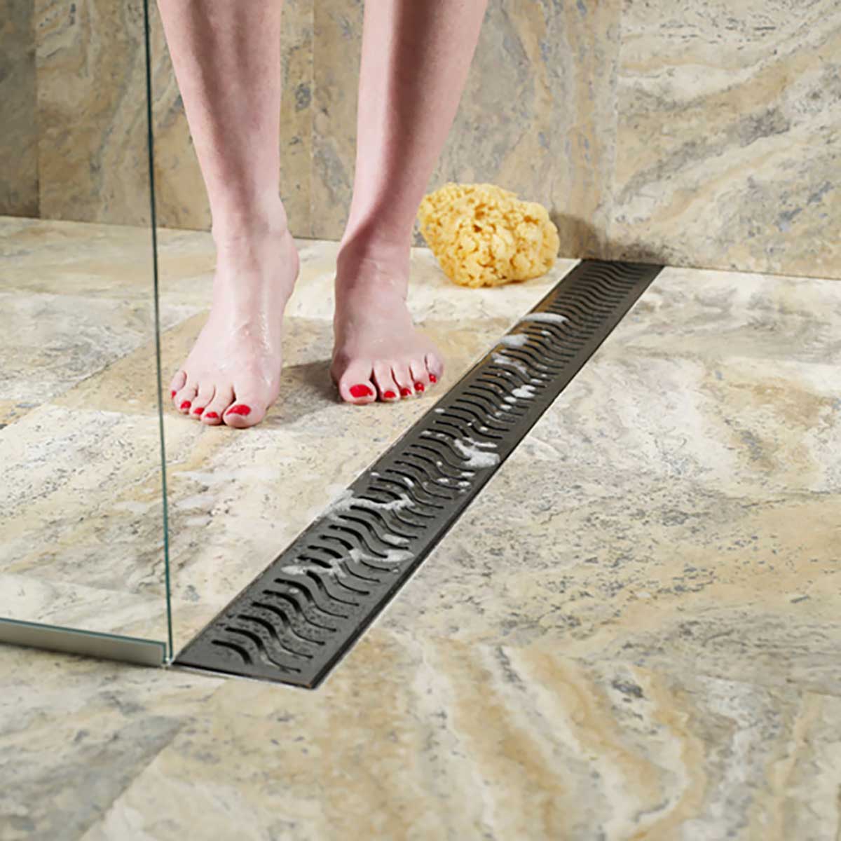 QuARTz Linear Shower Drain with Flag Grate - Oil Rubbed Bronze Installed in shower floor and women feet taking shower