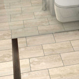 QuARTz Linear Shower Drain with Flag Grate - Oil Rubbed Bronze next to red flip flop in shower floor