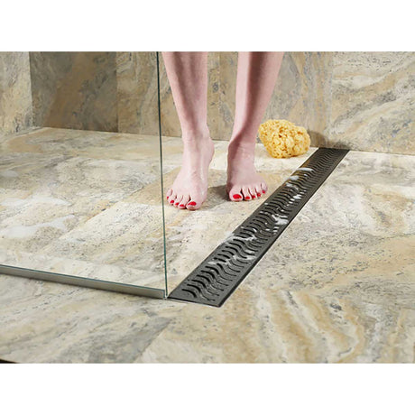 QuARTz Linear Shower Drain with Flag Grate - Oil Rubbed Bronze Installed in shower floor and women feet taking shower