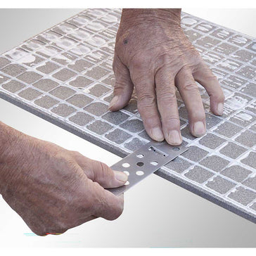 Person using a Rai Fix hook to install large format tile