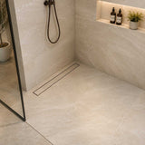 Oil rubbed bronze linear shower drain installed in a modern tiled shower