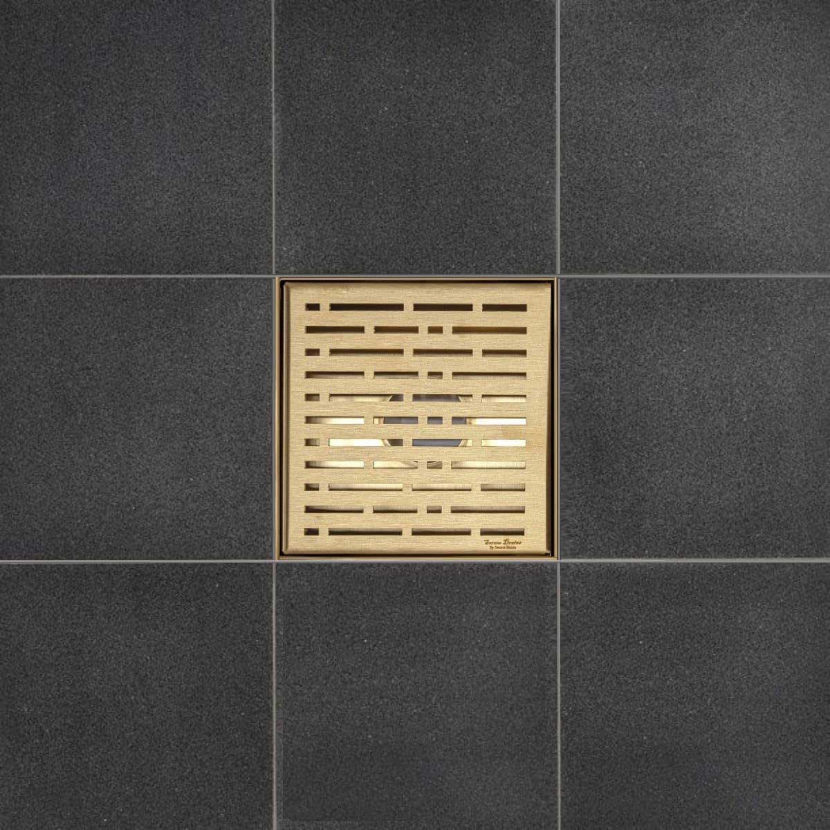 Bronze floor drain cover on dark gray tiled floor