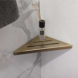 SereneDrains Stainless Steel Satin Gold Corner shower shelf mounted on a marble wall