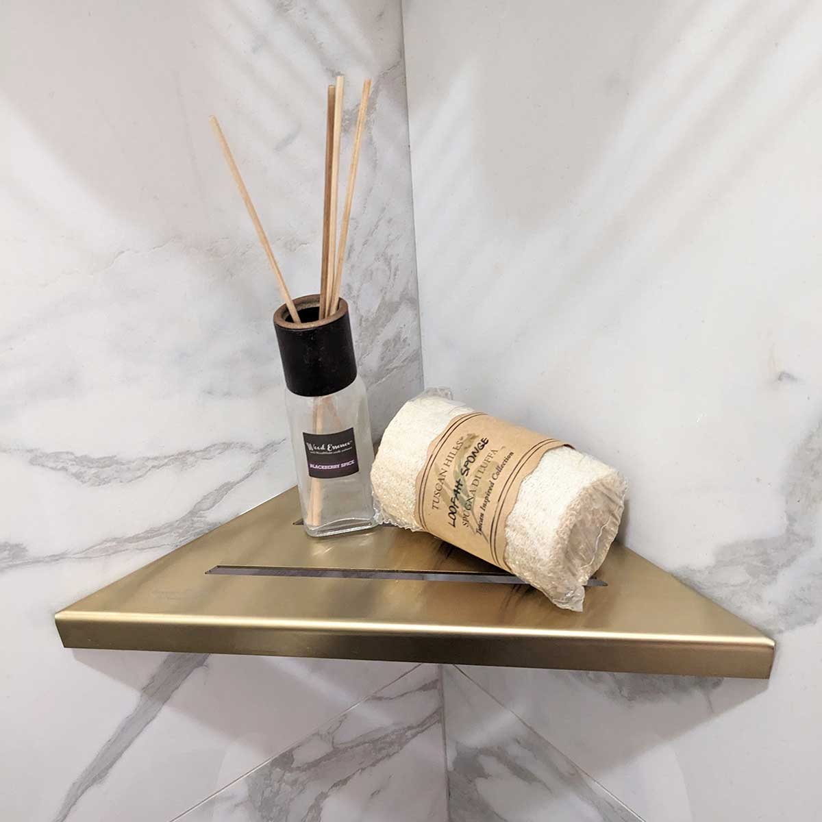 SereneDrains Stainless Steel Satin Gold Corner shower shelf mounted on a marble wall
