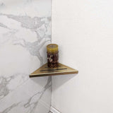 SereneDrains Stainless Steel Satin Gold Corner shower shelf mounted on a marble wall