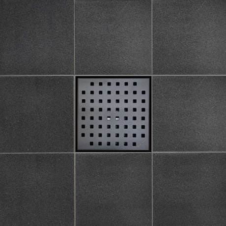 Black square drain cover on a tiled floor