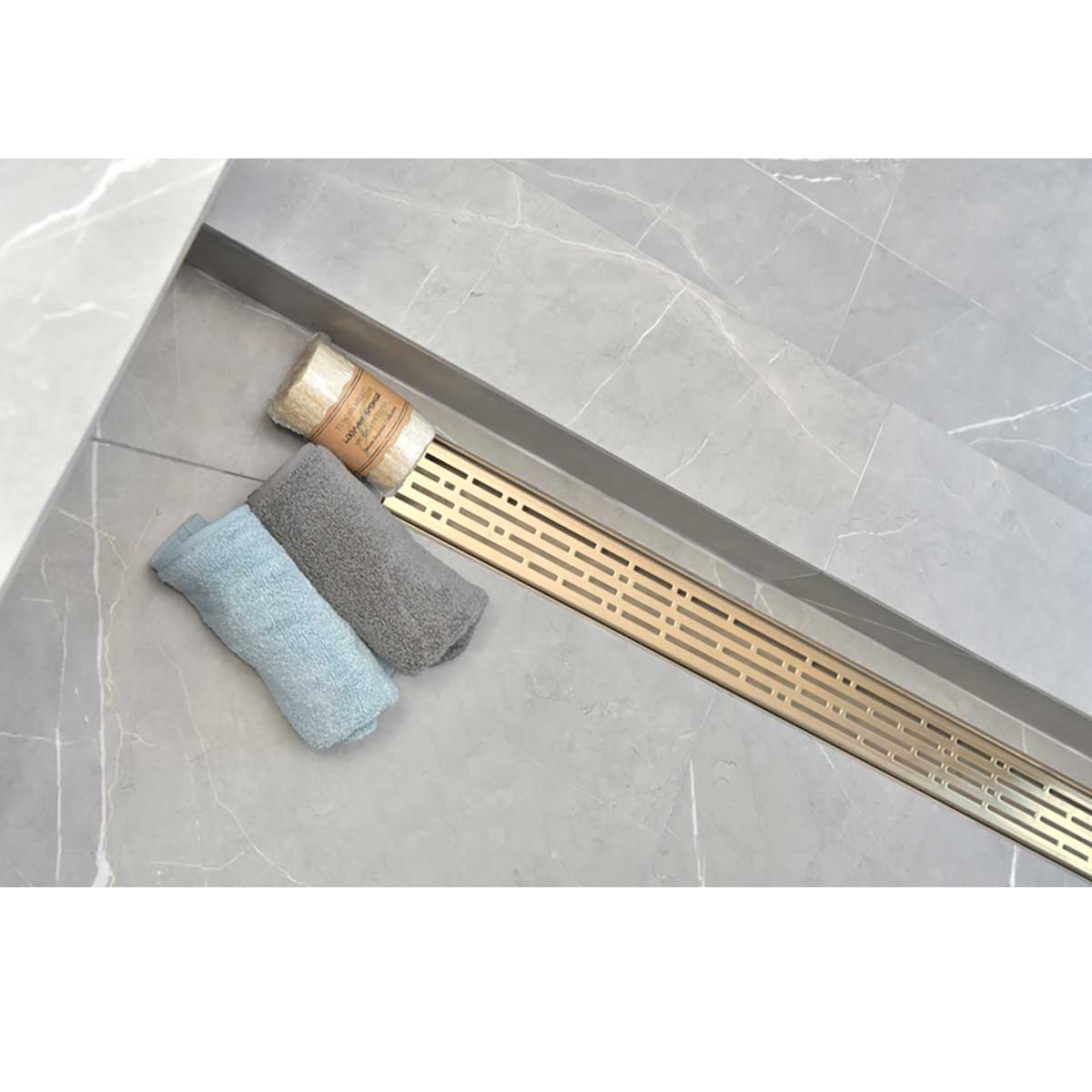 SereneDrain broken lane in Satin gold finish installed in shower over grey tile