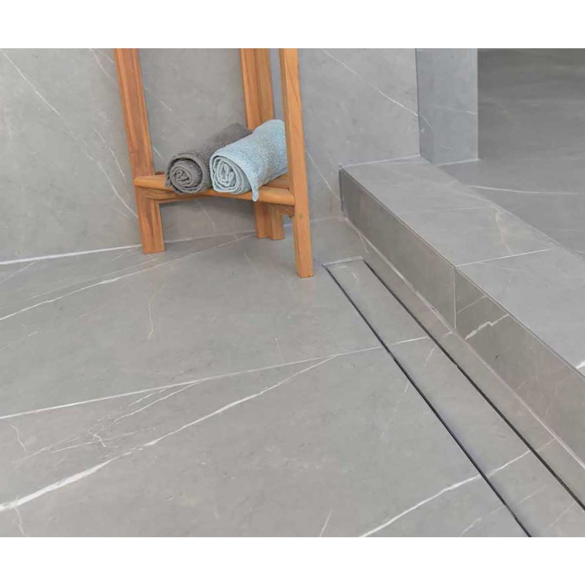 SereneDrains Linear Shower Drain Tile Insert Brushed Nickel over grey porcelain tile with teak bench