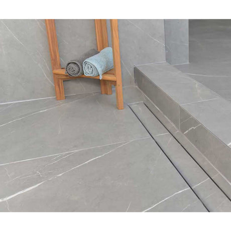 SereneDrains Linear Shower Drain Tile Insert Brushed Nickel over grey porcelain tile with teak bench