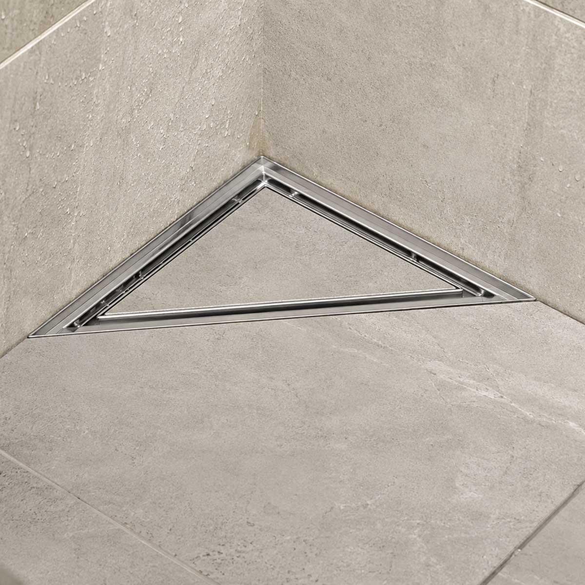 Triangle stainless steel shower floor drain installed in a modern tiled shower