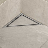 Triangle stainless steel shower floor drain installed in a modern tiled shower
