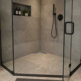 Corner triangle shower drain installed flush with shower floor tile