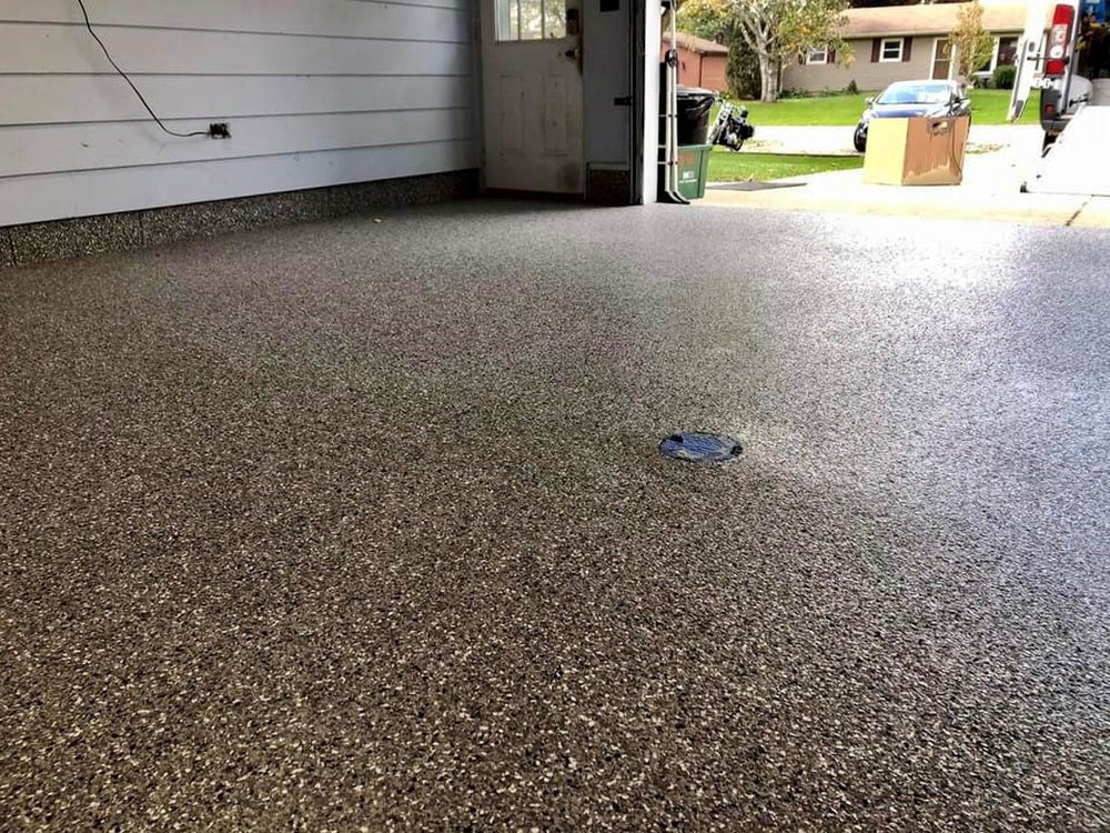 Polished concrete floor in a residential garage with visible speckles using Smith Paint Poly-SB