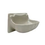 A small ceramic wall-mounted dish with a wavy, organic shape in a glossy off-white finish,