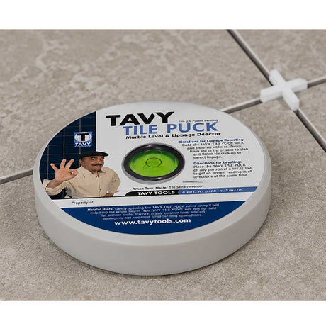 TAVY Tile Puck marble level and lippage detector placed on a porcelain tile floor during tile installation