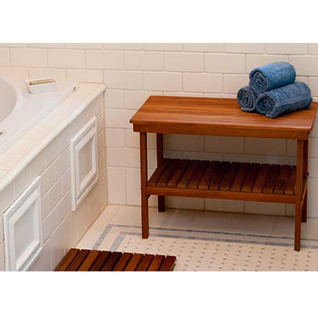 Teak storage bench beside freestanding bathtub
