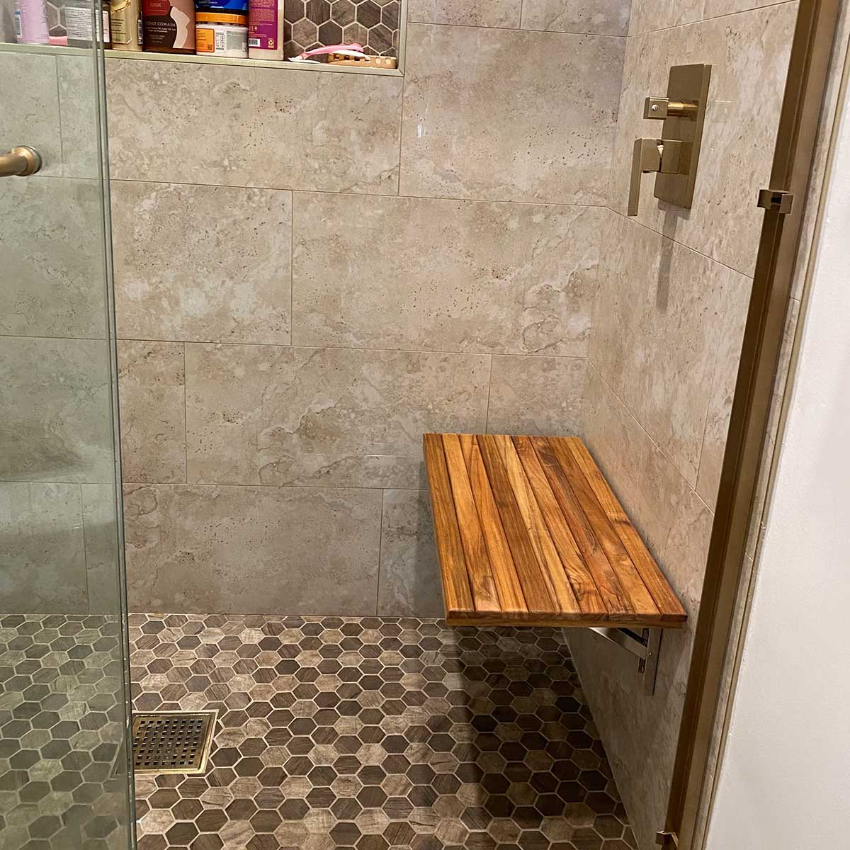 Teak wall mounted bench installed in walk in shower