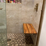 Teak wall mounted bench installed in walk in shower