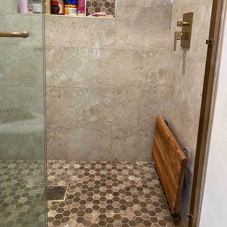 Fold down teak shower seat in luxury bathroom