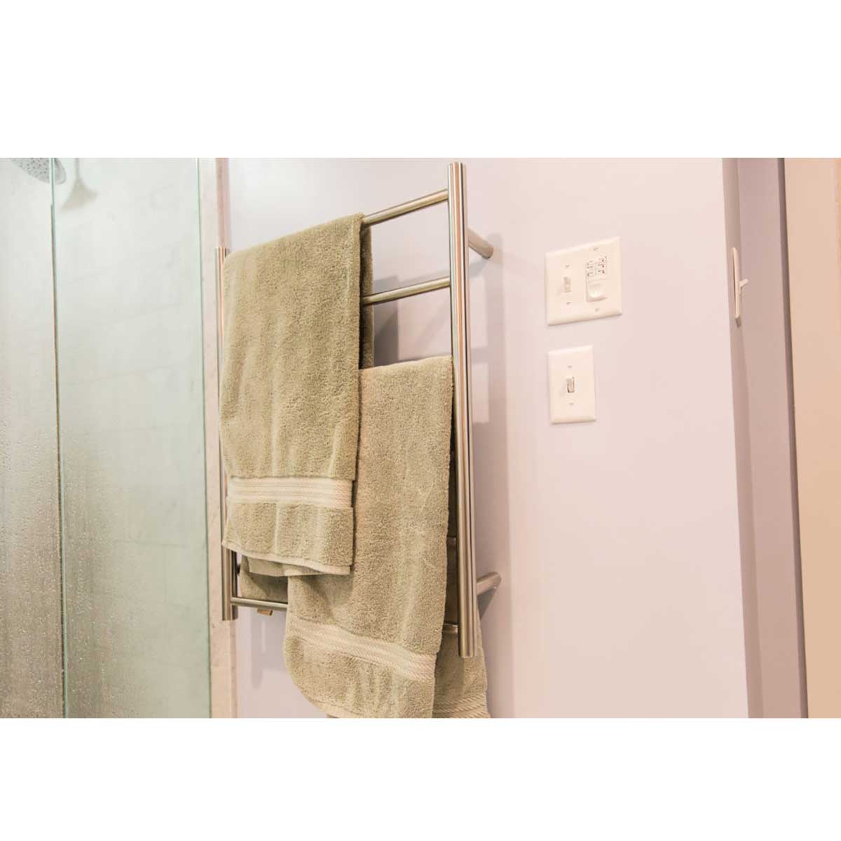 WarmUp Electric Towel Warmers - Chelsea Round with Green towels hanging on it in a bathroom.