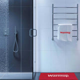 Bathroom with shower, towel rack, and mat featuring 'Warmup' brand.