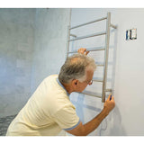 Person installing WarmUp Electric Towel Warmer on a wall.